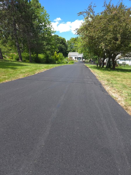 Freshly paved long steep asphalt driveway in Maine by Discount Asphalt Paving